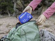Adventure Medical Day Tripper Lite Medical Kit being placed in a backpack